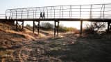 A footbridge spans a completely dry river bed in Porterville, Calif.