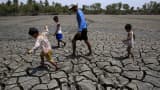 A father with his children walk over the cracked soil of a 1.5 hectare dried up fishery at the Novaleta town in Cavite province, south of Manila. The drought-inducing El Nino weather phenomenon continue to affect farmlands in the provinces resulting to more damaged crops.