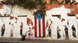 A woman walks by a rundown building on in Old San Juan, Puerto Rico.
