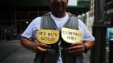 A man advertises for a jewelry store that buys gold in Manhattan in New York City.
