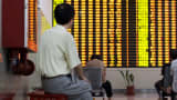 An investor watches stock prices in Shanghai, China.