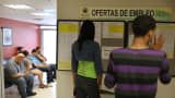 People look at the job listings posted at an unemployment office in San Juan, Puerto Rico.