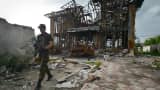 A serviceman walks in front of a destroyed house near Donetsk in eastern Ukraine.