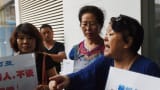 Relatives of passengers on missing Malaysia Airlines MH370 speak outside the Malaysia Airlines office in Beijing, expressing anger and disbelief after Malaysia's prime minister said wreckage found on a French Indian Ocean island was from the plane.