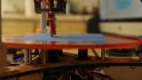 A build-it-yourself 3-D printer made by Deltaprintr prints a three-dimensional object made of plastic.
