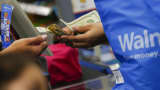 A customer receives cash change from a cashier at a Walmart in the Porter Ranch neighborhood of Los Angeles.