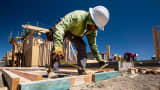 A worker measures wood for a house under construction at the KB Home Vineyard Crossing Community in Livermore, California.