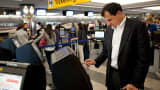 A passenger attempts to check himself in from a self-service kiosk at LaGuardia Airport in New York.
