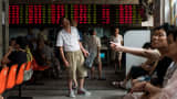 Investors monitor screens showing stock market movements at a brokerage house in Shanghai