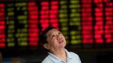 An investor monitors screens showing stock market movements at a brokerage house in Shanghai, China.