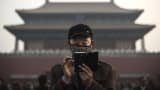 A Chinese man uses his smartphone on a hazy day outside the Forbidden City in Beijing, China. Taken on November 20, 2014.