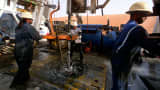 Workers drill at the Saudi Aramco oil field complex facilities at Shaybah, Saudi Arabia.
