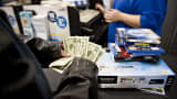 A customer counts his money as he prepares to pay for merchandise at a Best Buy store in Peoria, Ill.