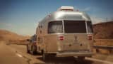 Rear view of silver airstream trailer on the open road.