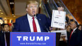 Donald Trump holds up a signed pledge at Trump Tower in New York September 3, 2015.