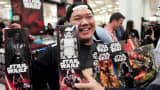 A shopper shows off his haul of new merchandise from the upcoming film 'Star Wars: The Force Awakens' at a department store open just after midnight on 'Force Friday' in Sydney, September 4, 2015.