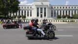 Motorcyclist ride by the Federal Reserve Building in Washington, DC.