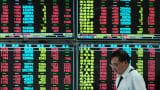 An investor observes stock market at a stock exchange hall in Jiujiang, China.