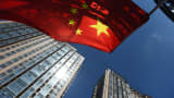 A Chinese flag flies near apartment buildings in Beijing.