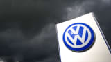 Rain clouds are seen over a Volkswagen symbol at the main entrance gate at Volkswagen production plant in Wolfsburg, Germany.