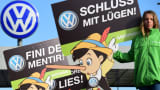 An activist holds up a sign reading 'Stop Lying' (Schluss mit Luegen) during a protest of environmental watchdog Greenpeace in front of the headquarters of German car maker Volkswagen in Wolfsburg, central Germany, on September 25, 2015.