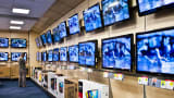 A shopper looks at televisions in a Best Buy store.