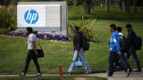 Pedestrians walk by a sign outside of the Hewlett-Packard headquarters in Palo Alto, California.