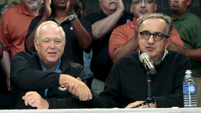 Fiat Chrysler Automobiles' deceased CEO Sergio Marchionne (R) and United Auto Workers union President Dennis Williams shake hands during a news conference in Detroit, Sept. 15, 2015.