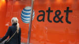 A pedestrian walks past an AT&T sign in New York.
