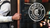 A man opens the door to a Chipotle restaurant in New York.