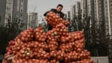 A Chinese vendor unloads onions at a local food market in Beijing.