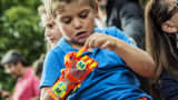 A young boy Maxence, born with a right hand malformation, examines his new 3D-printed hand given to him by the Association for the Study and Assistance of Child Amputees (ASSEDEA) on August 17, 2015 in Cessieu.