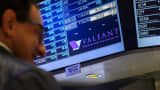 Traders work on the floor of the New York Stock Exchange underneath a board showing the name of Valeant Pharmaceuticals shortly before the opening of the markets in New York October 22, 2015.