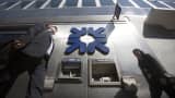 A logo sits above an automated teller machine (ATM) outside a Royal Bank of Scotland Group (RBS) bank branch in London, U.K.