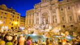 The famous Trevi Fountain in Rome, Italy surrounded by a large crowd of tourists.
