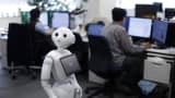 Pepper the humanoid robot, manufactured by SoftBank Group Corp., stands as employees work in the Orange Arch Inc. offices in Tokyo, Japan.