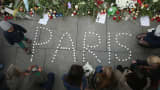 People finish arranging candles into the word 'Paris' next to flowers and messages left at the gate of the French Embassy following the recent terror attacks in Paris on November 14, 2015 in Berlin, Germany.