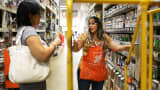 A Home Depot employee helps a customer as she shops in the paint department at the store in Miami, Florida.