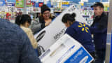 Shoppers load a television set into their cart at a Walmart store in Secaucus, New Jersey.