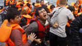 A Syrian refugee cries while disembarking from a flooded raft at a beach on the Greek island of Lesbos.