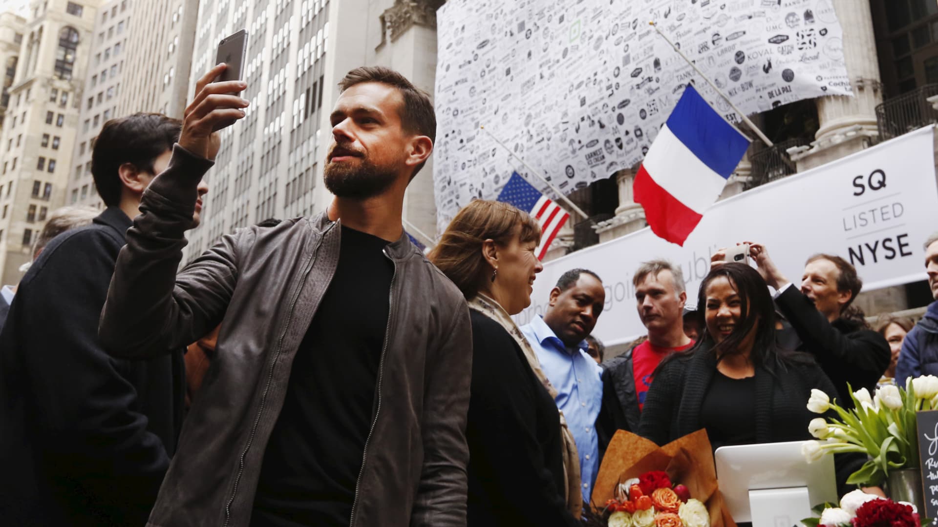 Jack Dorsey (L), CEO of Square and CEO of Twitter, live casts video while standing outside the New York Stock Exchange for the IPO of Square, in New York November 19, 2015.