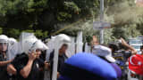 Police use pepper spray to prevent the breach of a barricade by Uighur seperatist supporters during a demonstration outside the Chinese embassy in Ankara on July 9, 2015.