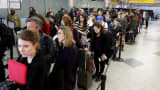 Travelers wait in line at a security checkpoint at New York's LaGuardia Airport, Nov. 25, 2015.