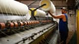 An employee loads a spool of white wool yarn onto a machine at the Woolrich woolen mill in Woolrich, Pennsylvania.
