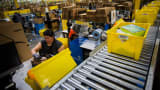 An employee packs a box at the Amazon.com Inc. fulfillment center on Cyber Monday in Robbinsville, New Jersey.