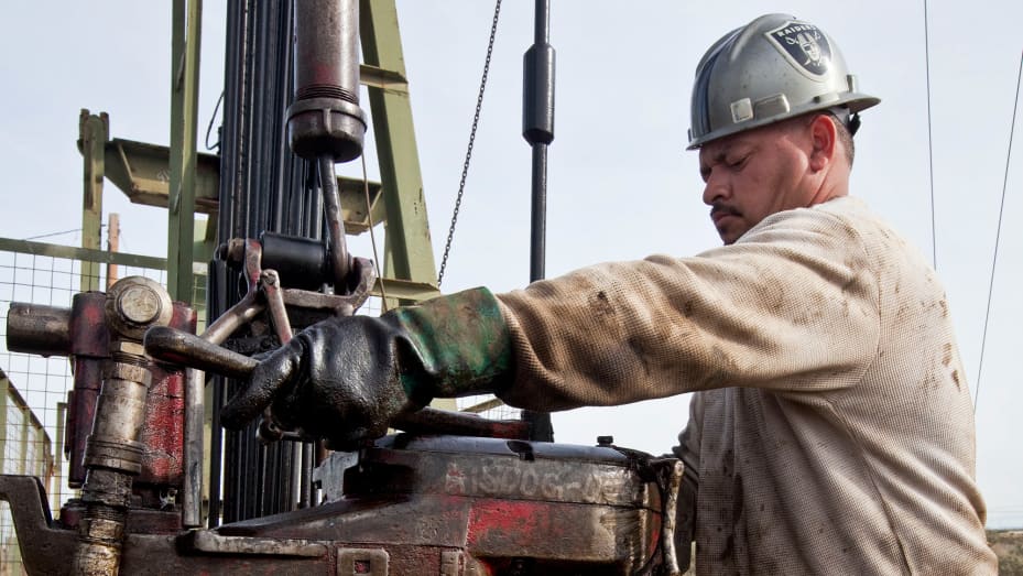 A floorhand operates a Chevron oil drilling rig near Taft, California.