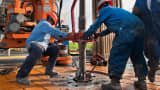 Oil workers make a pipe connection on a drilling rig near Encinal, Texas.