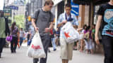 Shoppers walk with TJ Maxx and Macy's bags in Herald Square, New York.