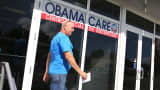 A man walks out of the UniVista Insurance company office after shopping for a health plan under the Affordable Care Act, also known as Obamacare in Miami.