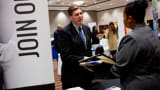 A company representative speaks with a job seeker during a Job Fair Giant career fair in Sterling Heights, Michigan.